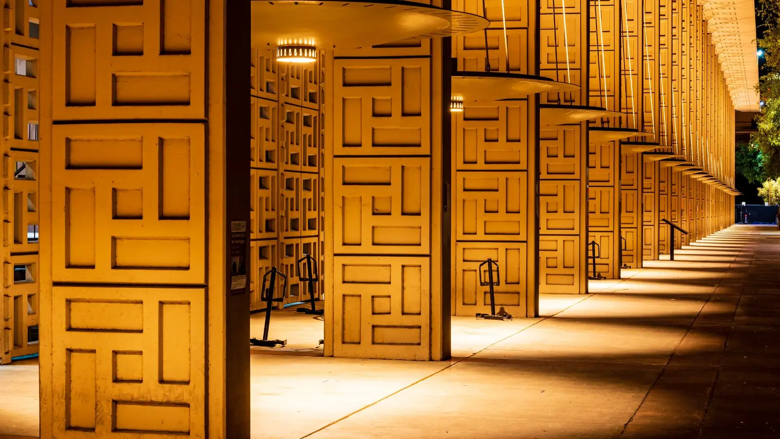The Stanford School of Medicine colonnade lit warm gold at night.
